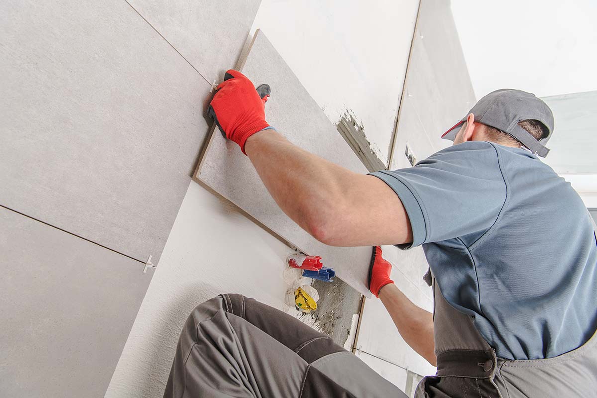 man putting bathroom tiles