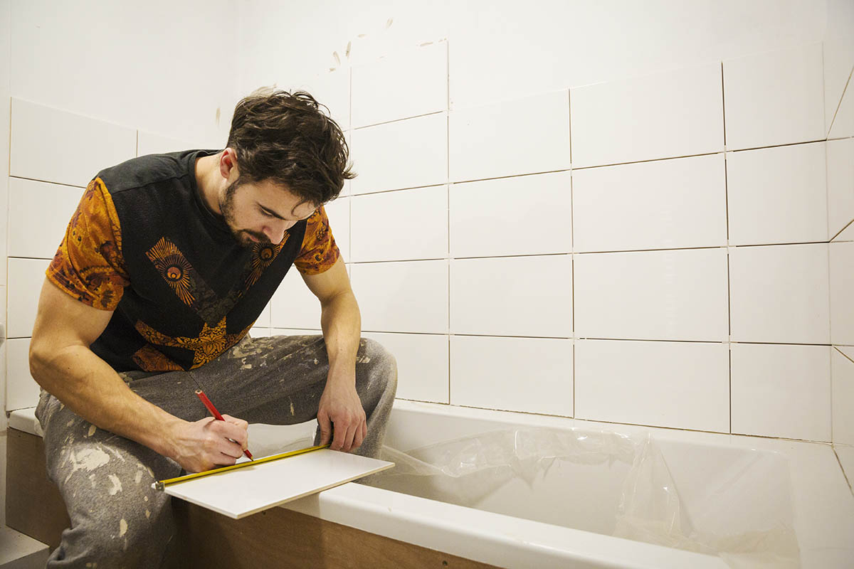 bathroom fitter installing tiles in a bathroom in surrey